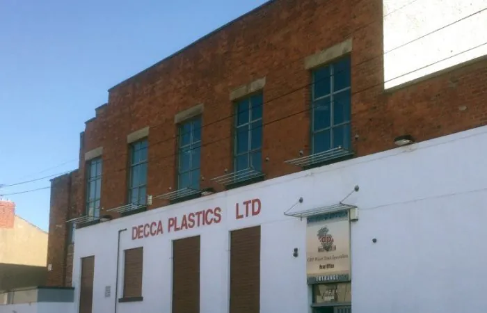 Exterior view of the Decca Plastics Ltd building with red brick and white paint